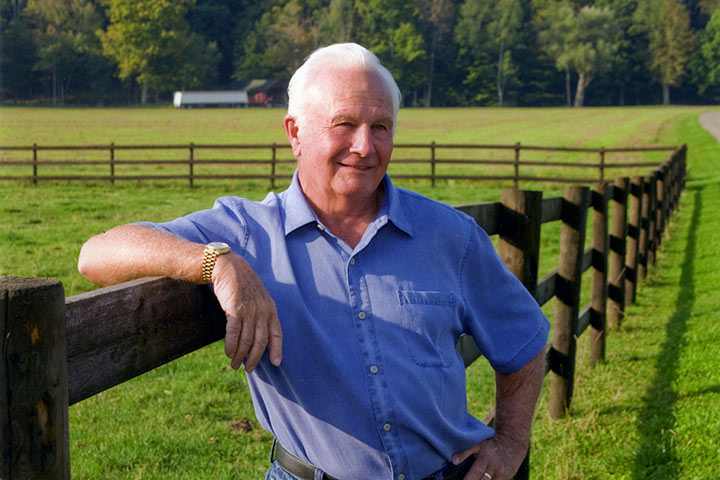 Phil Saunders posing against a fence for part 1 of the oral history interview