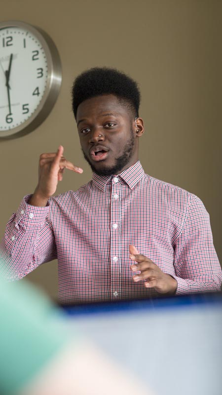 Student in a button up shirt signing