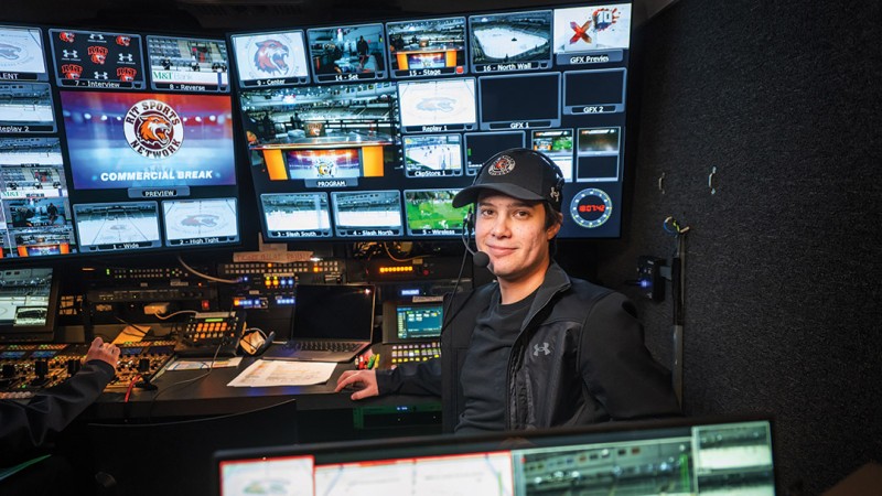 Vlad Simion sitting at broadcast desk for Sports Network