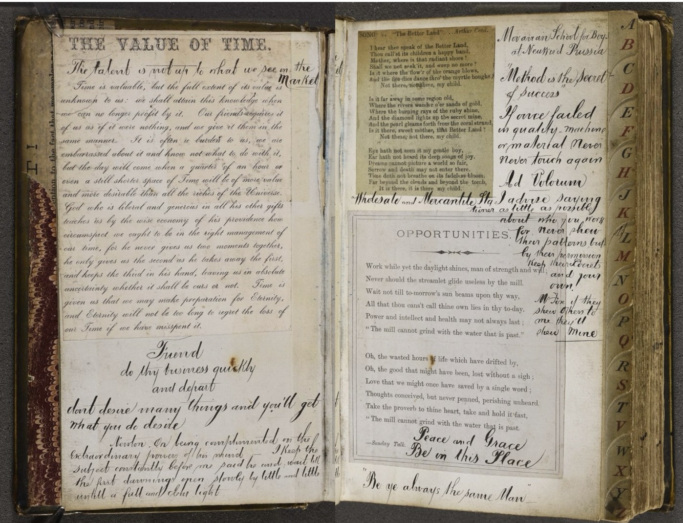 An open vintage scrapbook displays handwritten poems, motivational quotes, and pasted printed clippings